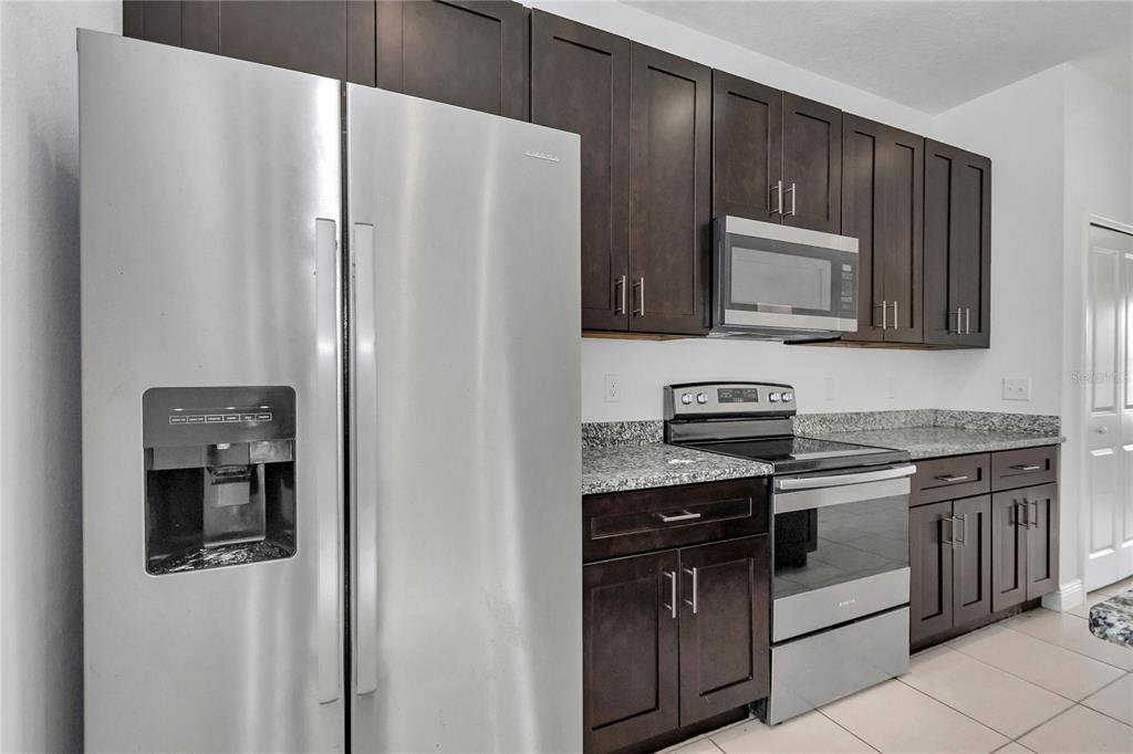 3650 Southwest 128th Place Ocala, FL 34473 - Photo 15 of 40 a kitchen with stainless steel appliances granite countertop a refrigerator stove and sink