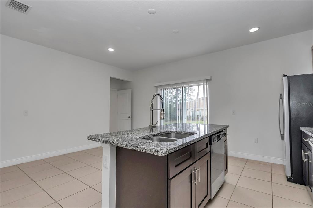 3650 Southwest 128th Place Ocala, FL 34473 - Photo 18 of 40 a kitchen with stainless steel appliances granite countertop a sink and a refrigerator