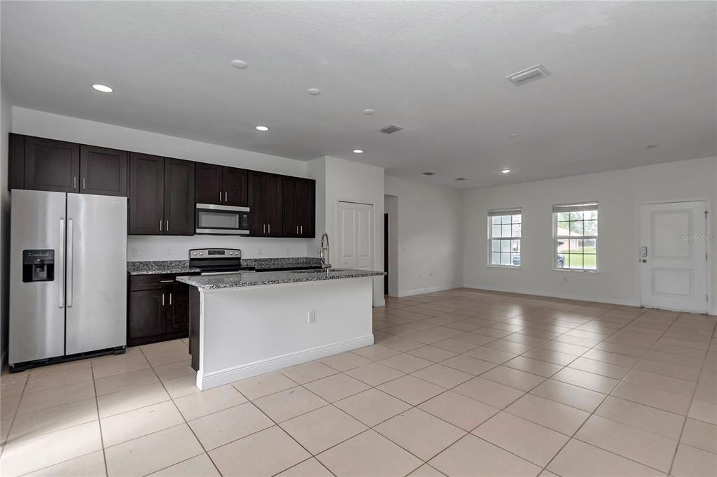 3650 Southwest 128th Place Ocala, FL 34473 - Photo 19 of 40 a kitchen with stainless steel appliances granite countertop a refrigerator and a stove top oven
