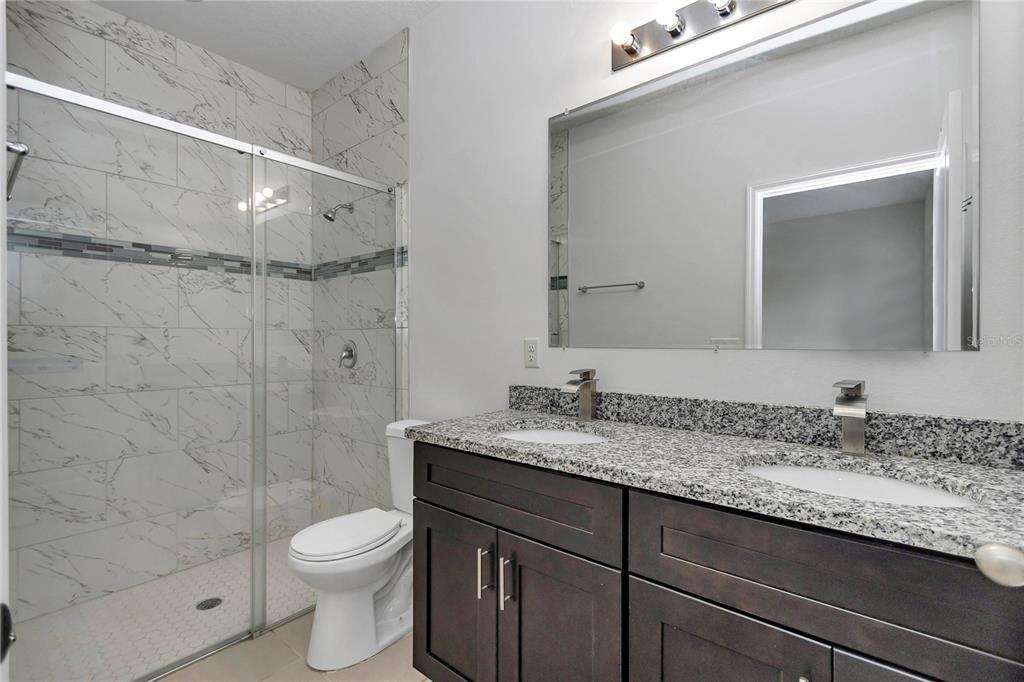 3650 Southwest 128th Place Ocala, FL 34473 - Photo 28 of 40 a bathroom with a granite countertop sink a toilet and shower