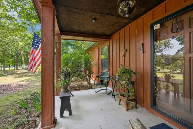 a view of a porch with chairs and floor to ceiling window
