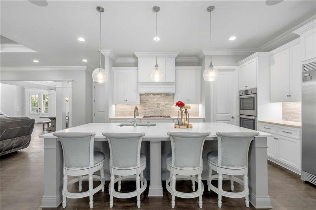 5055 Pointer Ridge Flowery Branch, GA 30542 - Photo 16 of 79 a kitchen with stainless steel appliances kitchen island granite countertop a dining table chairs and white cabinets