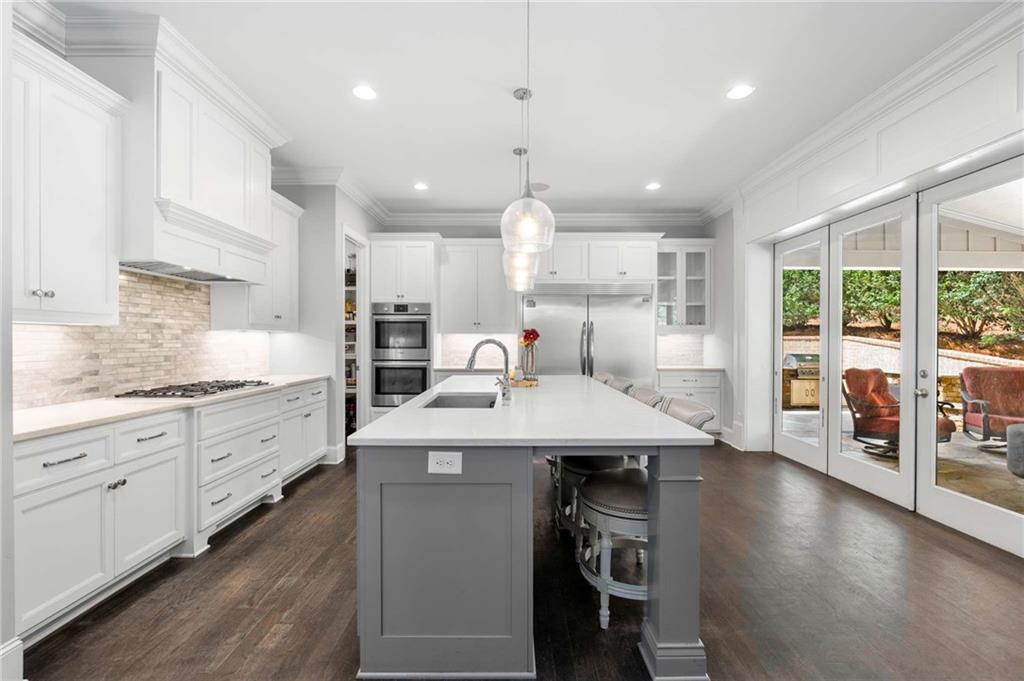 5055 Pointer Ridge Flowery Branch, GA 30542 - Photo 25 of 86 a kitchen with stainless steel appliances kitchen island granite countertop a sink and cabinets