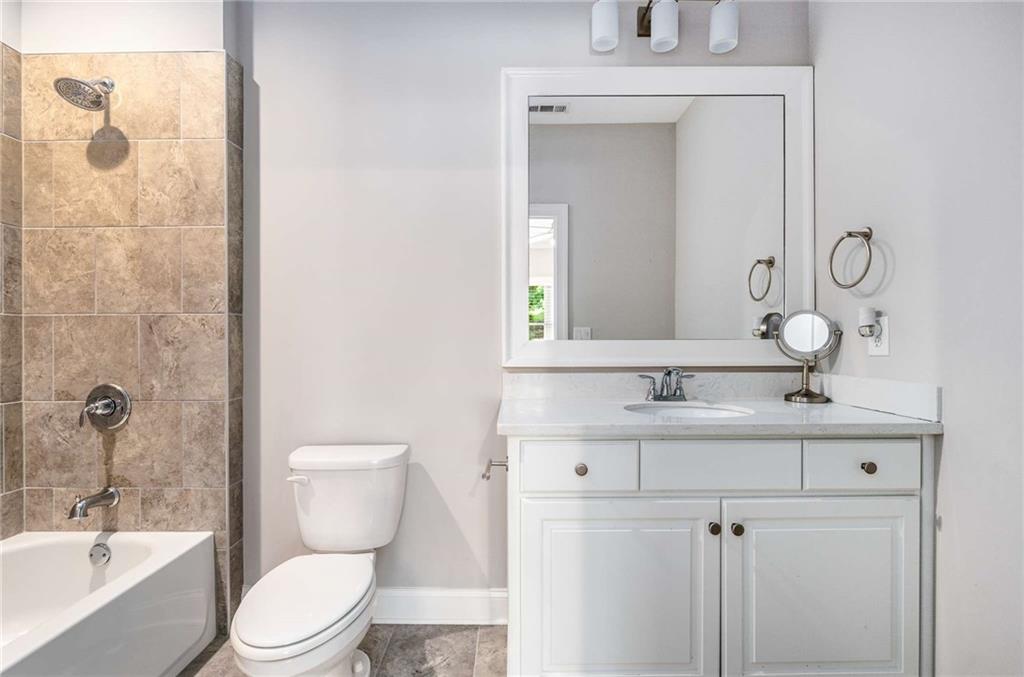 5055 Pointer Ridge Flowery Branch, GA 30542 - Photo 38 of 79 a bathroom with a toilet a sink a mirror a shower and vanity