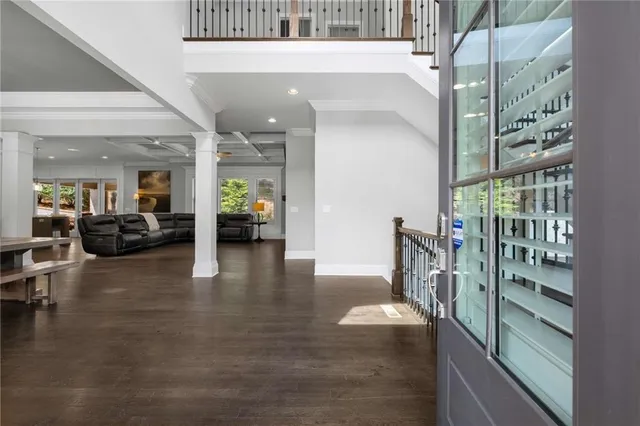 a kitchen with stainless steel appliances kitchen island granite countertop a dining table chairs and white cabinets
