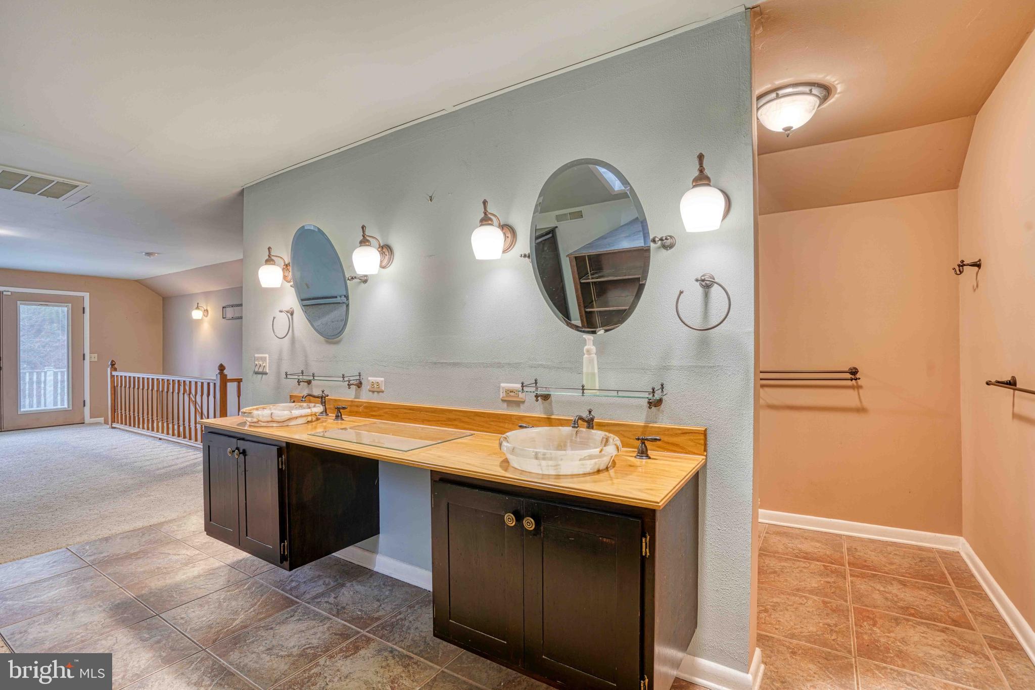 14957 Cherry Lane Ridgely, MD 21660 - Photo 45 of 66 a bathroom with a double vanity sink and a mirror