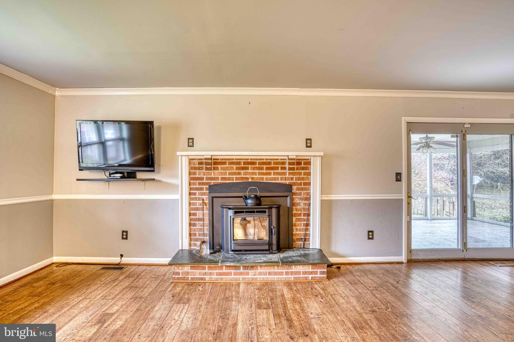 14957 Cherry Lane Ridgely, MD 21660 - Photo 5 of 66 a living room with a fireplace windows and a flat screen tv