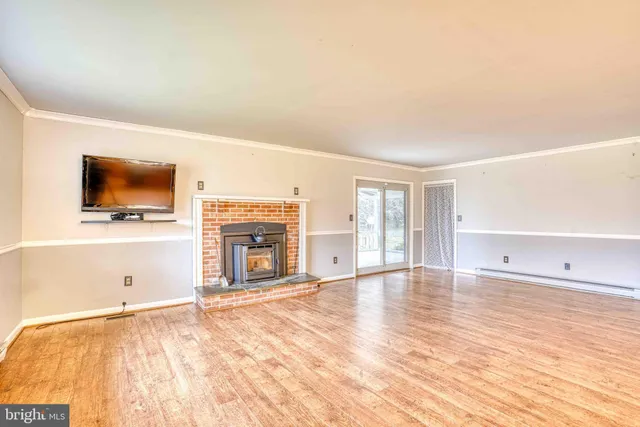 a view of an empty room with a fireplace and a flat screen tv