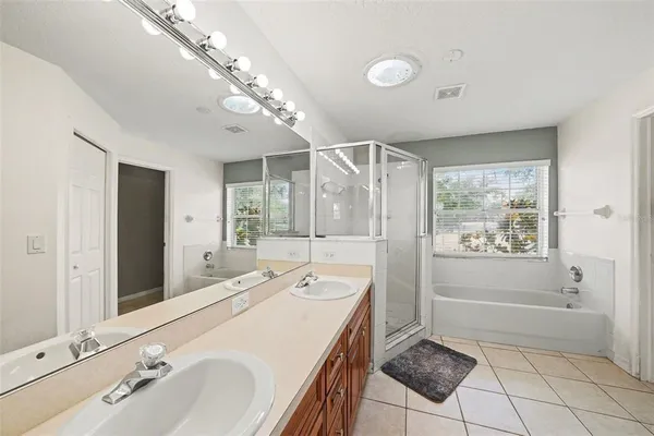 a spacious bathroom with a tub sink shower and mirror