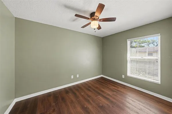 an empty room with a window and a fan