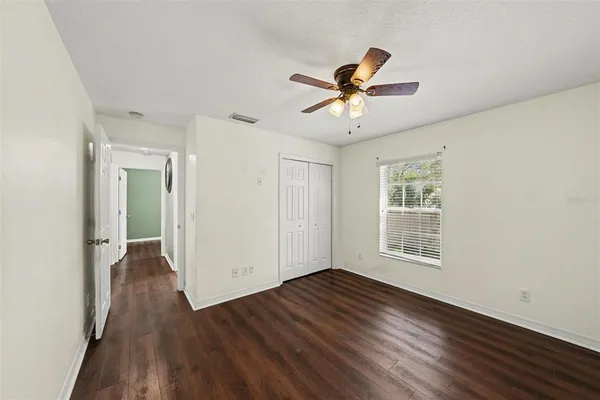 a view of empty room with wooden floor and window