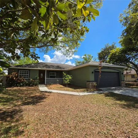 a front view of house with yard and trees in the background