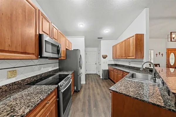 a kitchen with stainless steel appliances granite countertop a sink stove and microwave