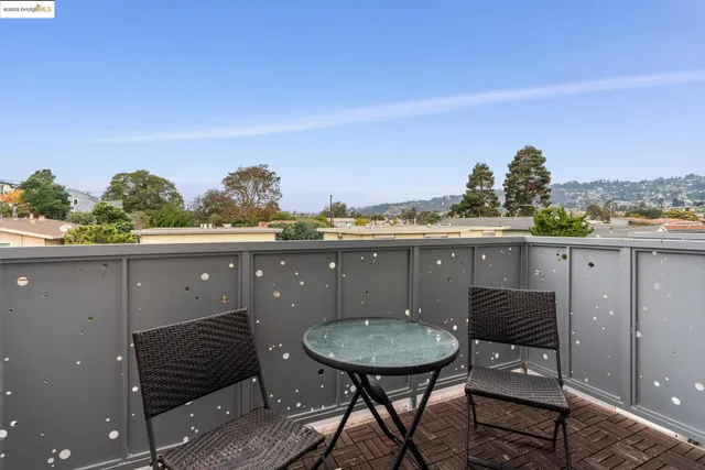 a balcony with table and chairs