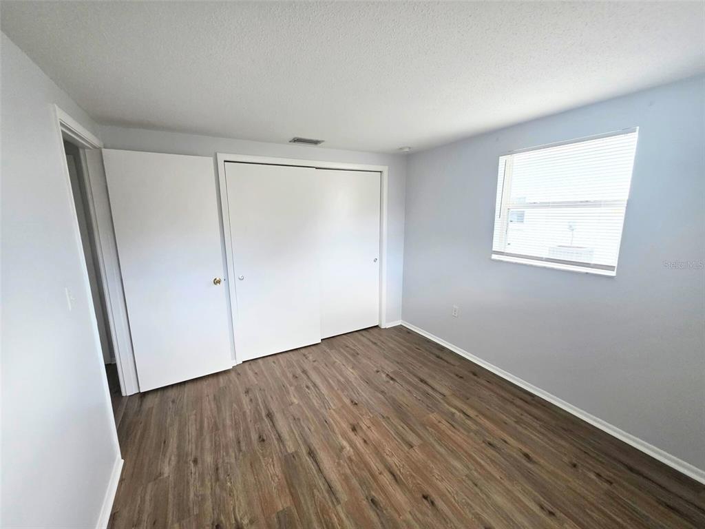 546 Briarwood Road Venice, FL 34293 - Photo 13 of 20 an empty room with wooden floor and windows