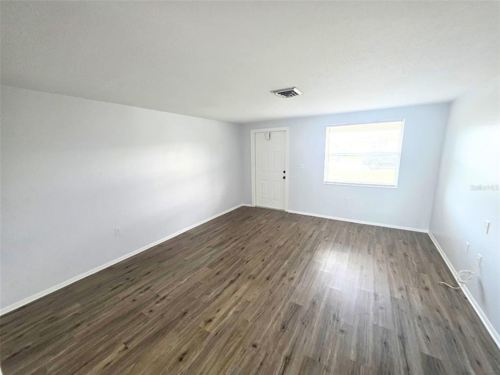 546 Briarwood Road Venice, FL 34293 - Photo 5 of 20 an empty room with wooden floor and windows