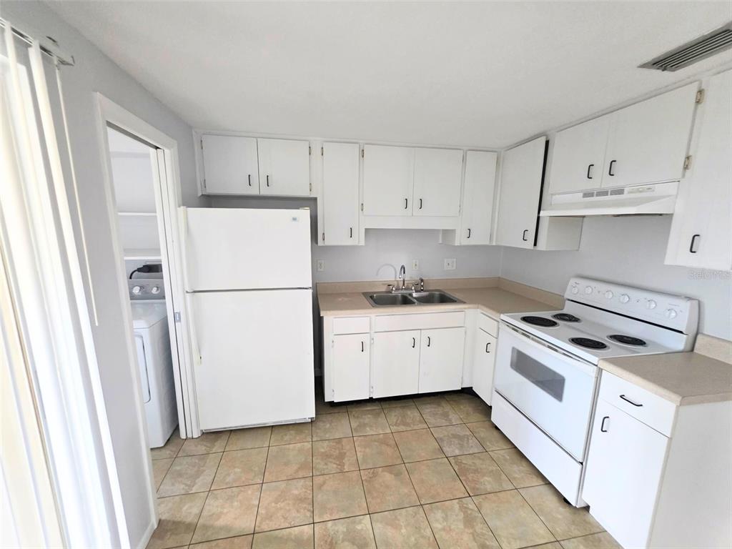 546 Briarwood Road Venice, FL 34293 - Photo 9 of 20 a kitchen with cabinets and white appliances