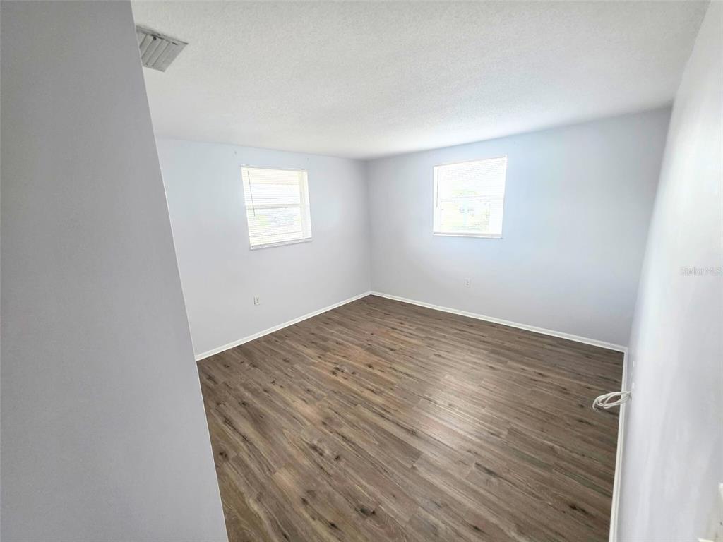 546 Briarwood Road Venice, FL 34293 - Photo 10 of 20 an empty room with wooden floor and windows