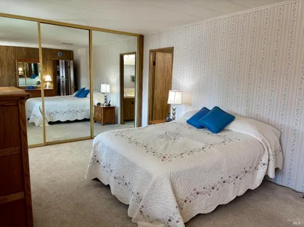 a bedroom with a bed and large mirror