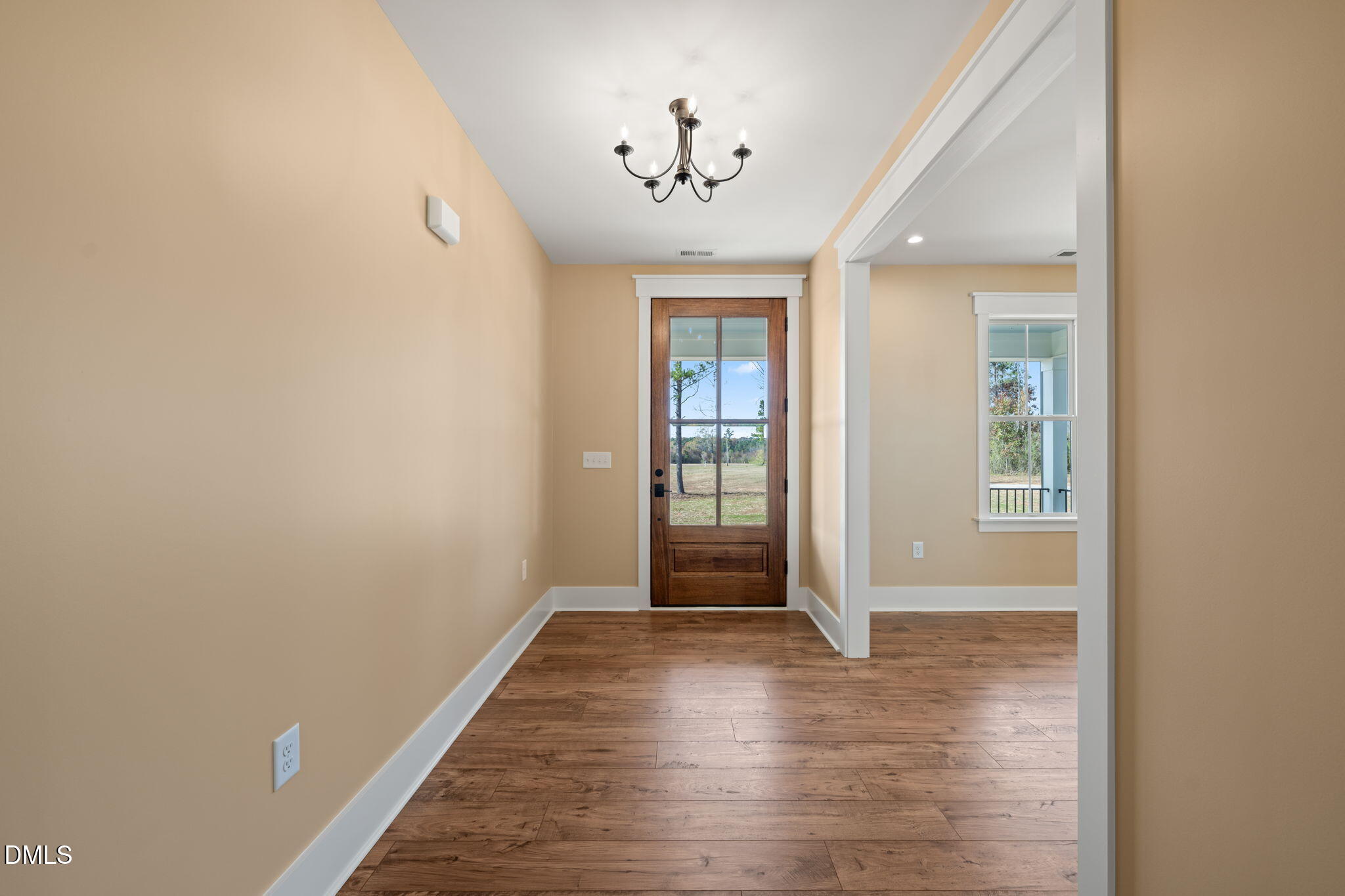 13887 Burgess Road Middlesex, NC 27557 - Photo 4 of 45 a view of a hallway with wooden floor and a chandelier