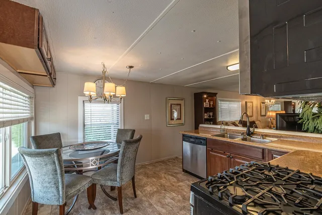 a kitchen with stainless steel appliances a table and chairs in it
