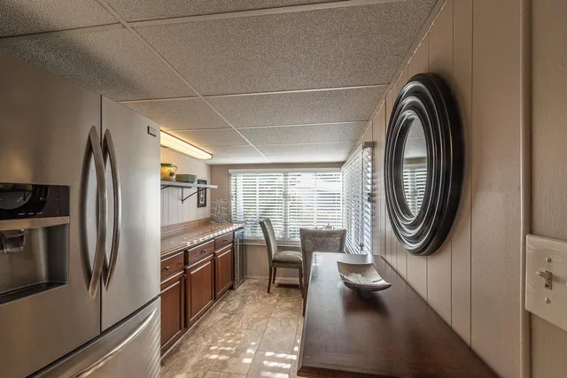 a kitchen with stainless steel appliances a table and chairs in it