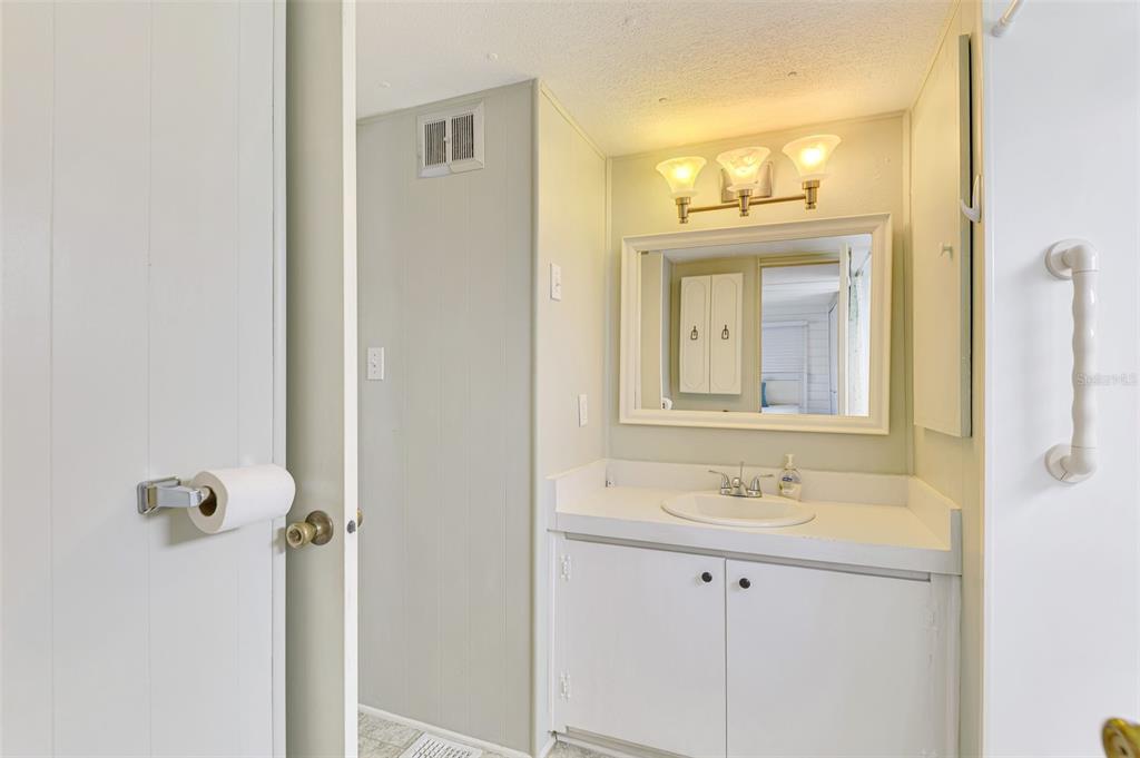 259 Inner Drive East Venice, FL 34285 - Photo 17 of 26 a bathroom with a sink vanity and mirror