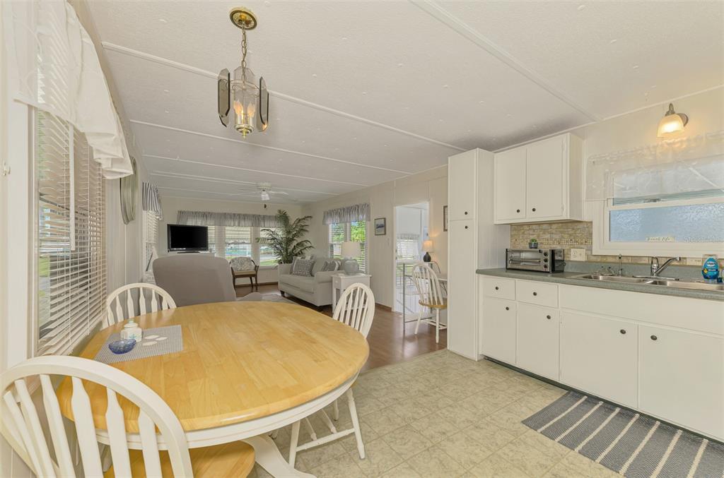 259 Inner Drive East Venice, FL 34285 - Photo 7 of 26 a kitchen with stainless steel appliances kitchen island granite countertop a dining table chairs sink and cabinets