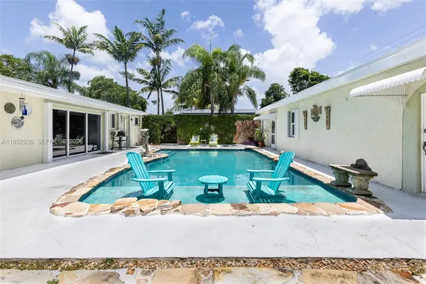 a view of a house with pool fire pit and a yard
