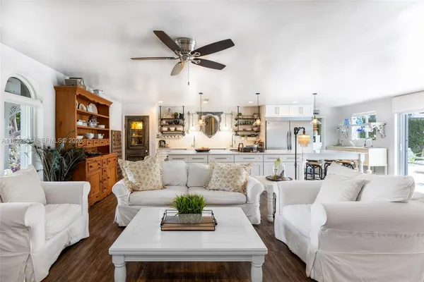 a living room with furniture and a view of kitchen