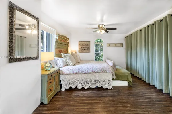 a spacious bedroom with a bed and a chandelier