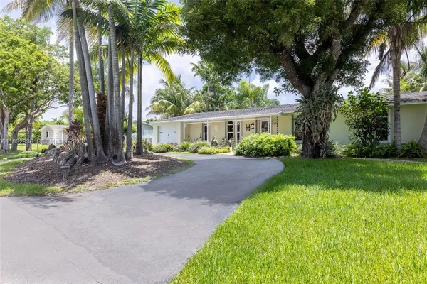 a front view of a house with yard and green space