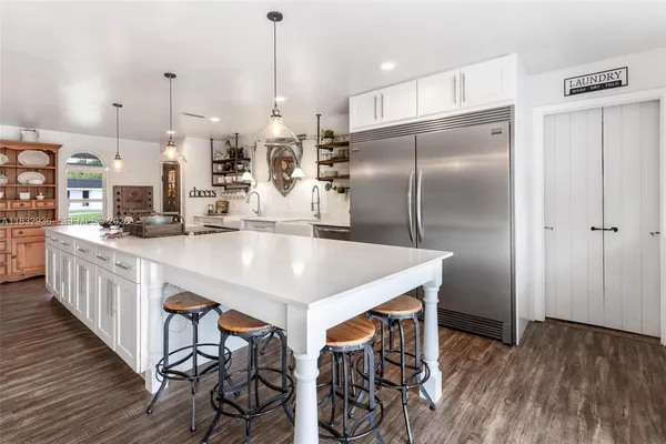 a kitchen with kitchen island a large counter top space and stainless steel appliances