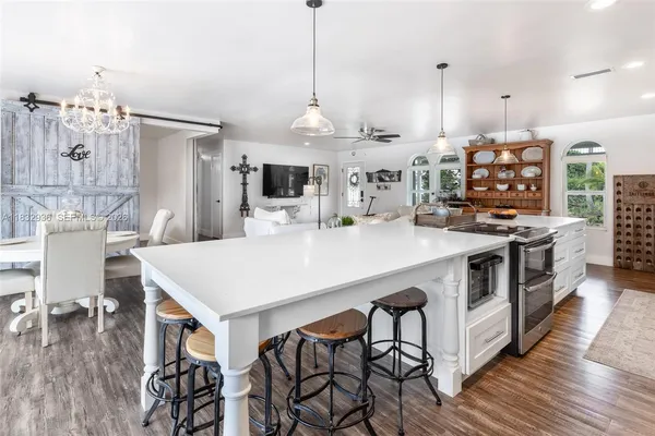 a kitchen with stainless steel appliances a stove a table and chairs