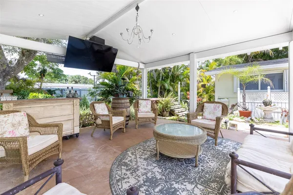 a living room with patio furniture and a large window