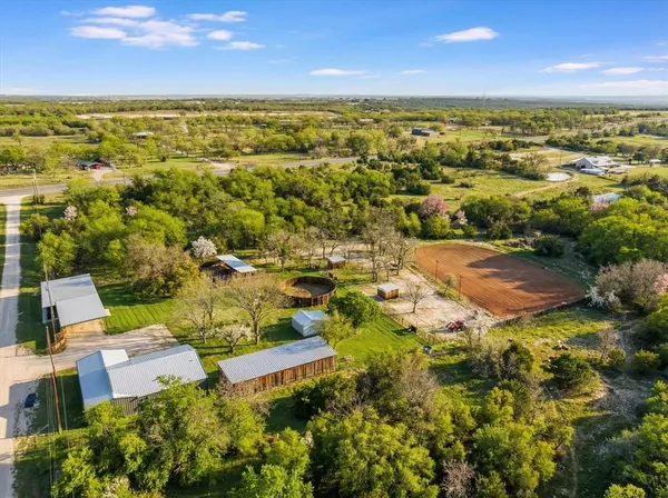 an aerial view of residential houses with outdoor space and trees