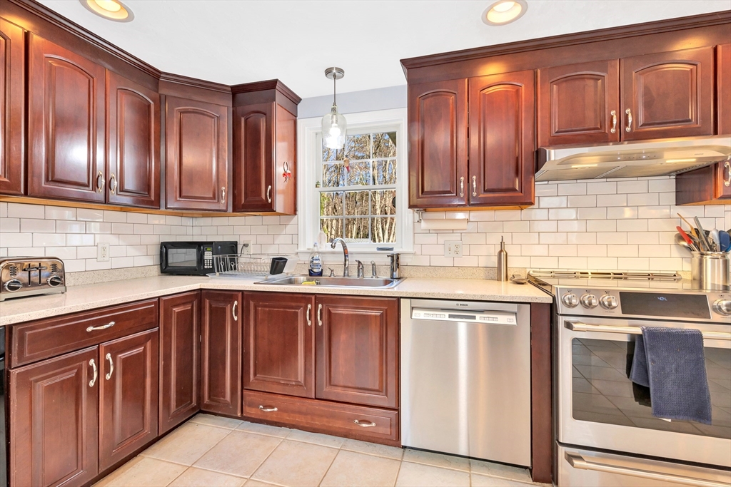 105 Hadley Road Merrimac, MA 01860 - Photo 9 of 31 a kitchen with stainless steel appliances granite countertop wooden cabinets a sink and dishwasher a stove with wooden cabinets