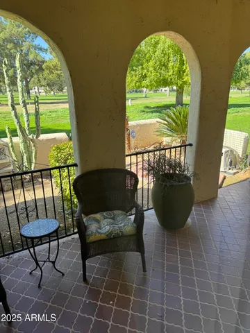 a view of a porch with furniture and a yard