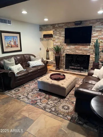 a living room with furniture a flat screen tv and a fireplace