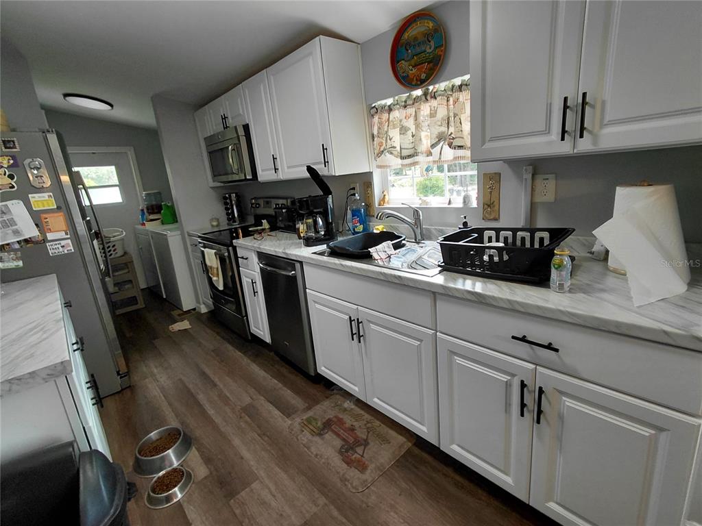 6758 North Capri Loop Hernando, FL 34442 - Photo 12 of 47 a kitchen with white cabinets and white appliances