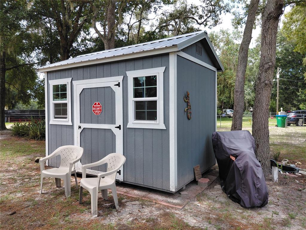 6758 North Capri Loop Hernando, FL 34442 - Photo 37 of 47 a view of a chairs and table in the back yard of the house
