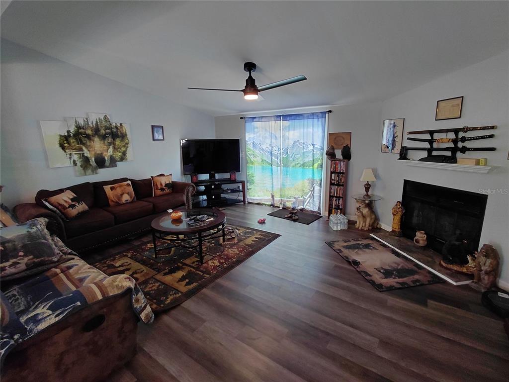 6758 North Capri Loop Hernando, FL 34442 - Photo 6 of 47 a living room with furniture flat screen tv and a fireplace