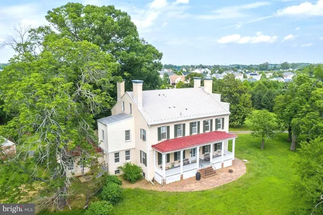 an aerial view of a house with swimming pool and big yard