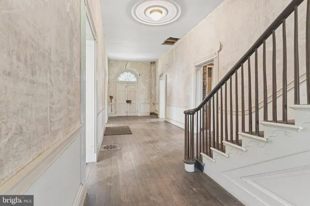 a view of a hallway with wooden floor and staircase