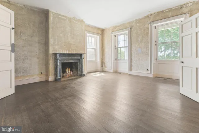 a view of empty room with wooden floor and fireplace