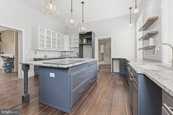 a kitchen with stainless steel appliances granite countertop wooden floors and sink