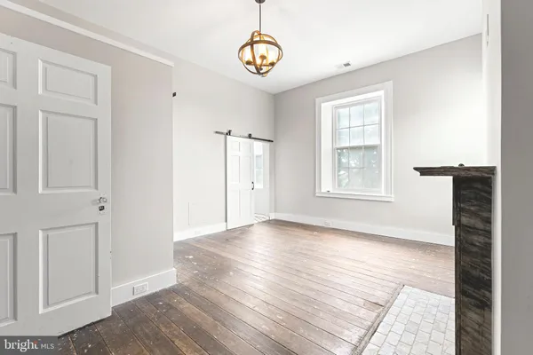 an empty room with wooden floor and window