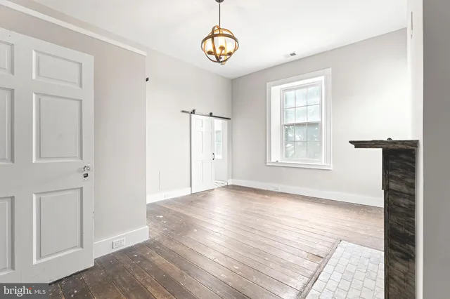 an empty room with wooden floor and window