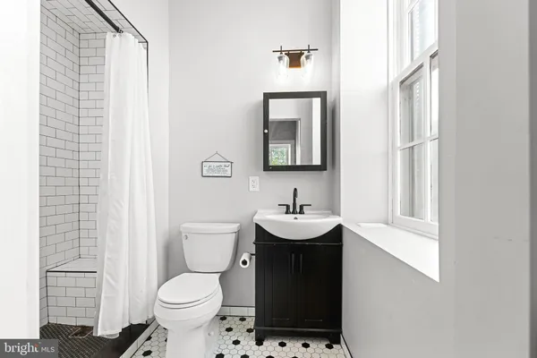 a bathroom with a toilet a sink and a mirror