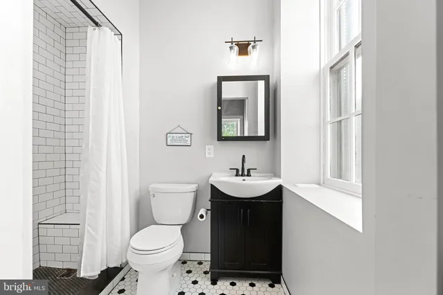 a bathroom with a toilet a sink and a mirror